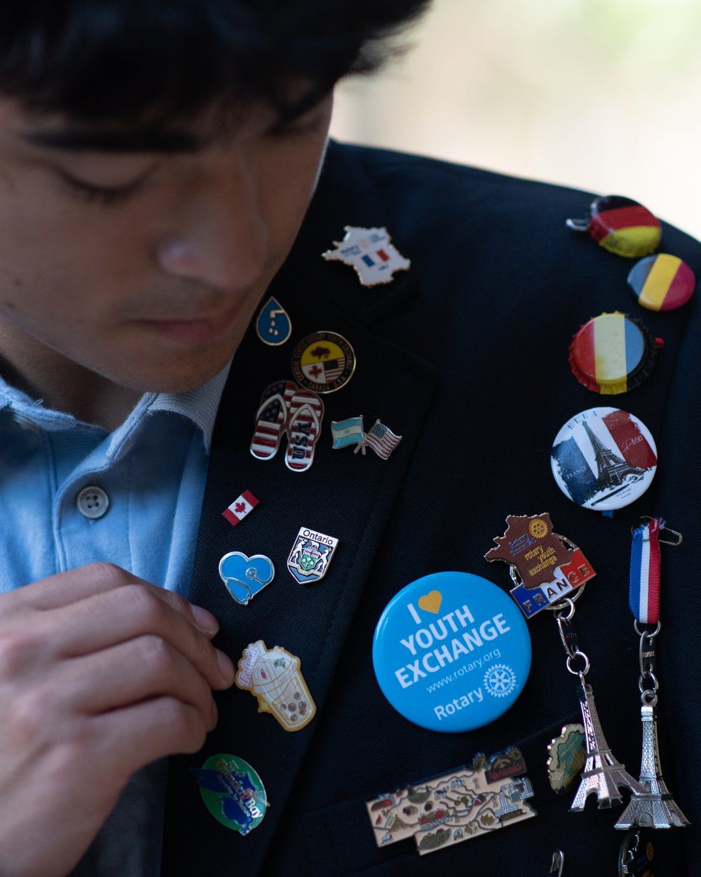 Utbytesstudent med Rotary Youth Exchange-pins och flaggor på sin blazer